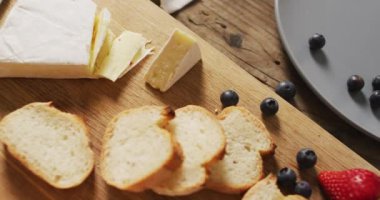 Tahta bir yüzeyde ekmek dilimleri, yaban mersini ve peynir videosu. Yemek, yemek ve yemek malzemeleri..