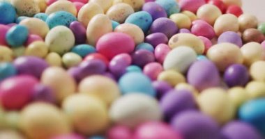 Ahşap bir yüzey üzerindeki renkli paskalya yumurtalarının videosu. Geleneksel Paskalya tatlıları.