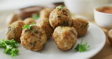 Beyaz tabakta taze yapraklar ve vejetaryen falafellerin videosu. Füzyon yiyecekler, taze sebzeler ve sağlıklı yeme konsepti.