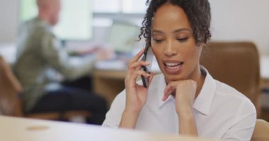 Yaratıcı ofiste akıllı telefondan konuşan Afro-Amerikan iş kadını. Yaratıcı ofiste iş ve finans.