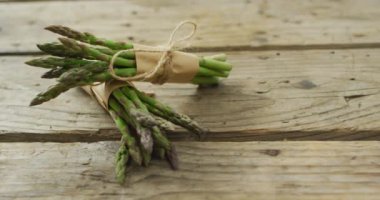 Ahşap arka planda iki taze kuşkonmaz paketi videosu. Füzyon yiyecekler, taze sebzeler ve sağlıklı yeme konsepti.