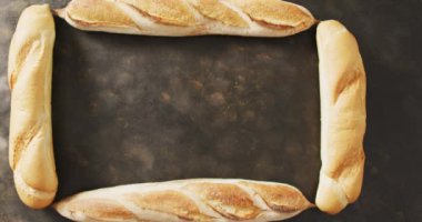 Siyah bir yüzey üzerinde dikdörtgen oluşturan dört ekmeğin videosu. Yemek, yemek ve yemek malzemeleri..