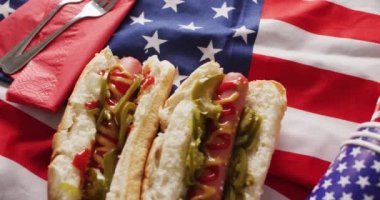 Amerikan bayrağı üzerinde hardallı ve ketçaplı sosisli sandviç videosu. Yemek, yemek ve yemek malzemeleri..
