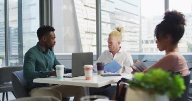 Engelli iş arkadaşlarıyla ve yaratıcı ofisteki belgelerle konuşan çeşitli iş adamları. Yaratıcı ofiste iş ve finans.