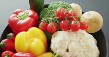 Gri arka planda taze sebzelerin yakın plan videosu. Füzyon yiyecekler, taze sebzeler ve sağlıklı yeme konsepti.