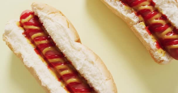 Vídeo Cachorros Quentes Com Mostarda Ketchup Uma Superfície Amarela Alimentos — Vídeo de Stock