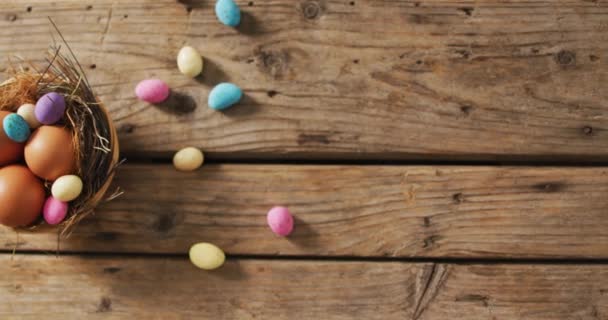 木製の表面に飾られたカラフルなイースターエッグのビデオ 季節のイースター伝統的な甘いお菓子 — ストック動画