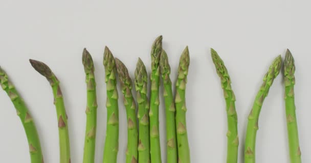 白い背景の上に新鮮なアスパラガスのビデオ 融合食品 新鮮な野菜や健康的な食事の概念 — ストック動画