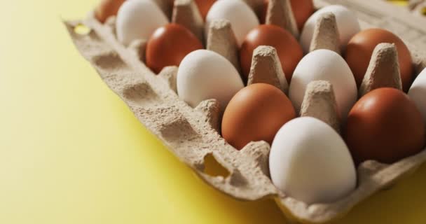 Vídeo Ovos Caixa Embalagem Uma Superfície Amarela Páscoa Sazonal Guloseimas — Vídeo de Stock
