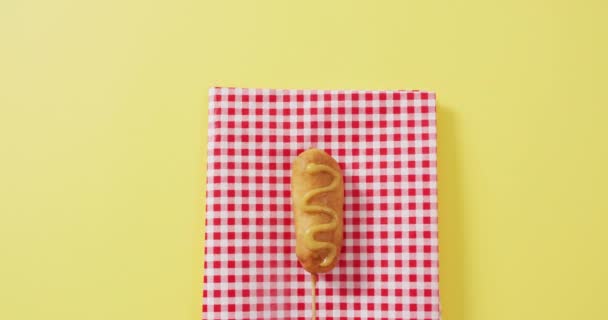 黄色い表面にマスタード付きのトウモロコシ犬のビデオ 食べ物料理ケータリング成分 — ストック動画