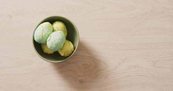 木製の表面にボウルに装飾されたカラフルなイースターエッグのビデオ 季節のイースター伝統的な甘いお菓子 — ストック動画