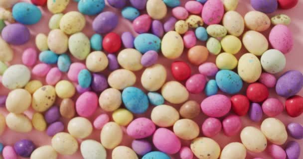 ピンク色の表面に飾られたカラフルなイースターエッグのビデオ 季節のイースター伝統的な甘いお菓子 — ストック動画