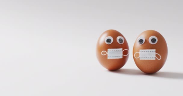 白い表面に目と顔のマスクを持つ卵のビデオ 流行期のイースターの伝統的な甘いお菓子 — ストック動画