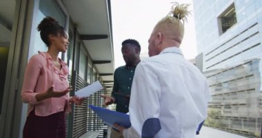 Çeşitli iş adamları yaratıcı ofisteki belgelerle gülümsüyor ve tartışıyorlar. Yaratıcı ofiste iş ve finans.