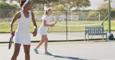 Sahada egzersiz yapan mutlu bayan tenisçilerin videosu. profesyonel tenis eğitimi, spor ve yarışma konsepti.