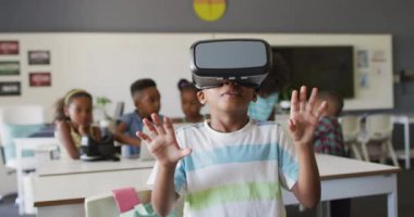 Sınıfta vr kulaklık takan mutlu Afrikalı Amerikalı bir çocuğun videosu. İlkokul eğitimi ve öğrenme kavramı.