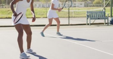 Sahada egzersiz yapan mutlu bayan tenisçilerin videosu. profesyonel tenis eğitimi, spor ve yarışma konsepti.