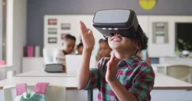 Sınıfta vr kulaklık takan mutlu Afrikalı Amerikalı bir çocuğun videosu. İlkokul eğitimi ve öğrenme kavramı.