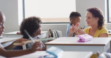 Afrikalı Amerikalı bir çocuğa matematik öğreten Kafkas kadın öğretmenin videosu. İlkokul eğitimi ve öğretmenlik mesleği.