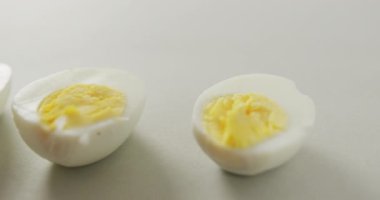 Gri arka planda kaynamış üç yarım yumurta videosu. Füzyon yiyeceği, pişirme, yumurta ve paskalya konsepti.
