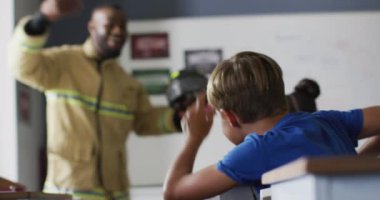Dersler sırasında farklı sınıflardan öğrencileri olan mutlu bir Afrikalı Amerikan öğretmeninin videosu. İlkokul eğitimi ve öğretmenlik mesleği.