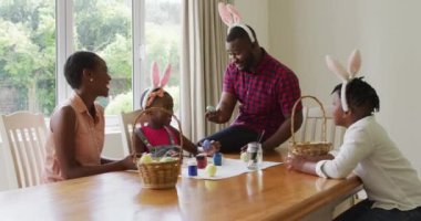 Afro-Amerikan ailesi evde paskalya yumurtası boyuyor. Paskalya bayramı ruhu ve eğlence kavramı