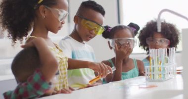 Kimya dersi sırasında deney yapan mutlu Afrikalı Amerikalı öğrencilerin videosu. İlkokul eğitimi ve öğrenme kavramı.