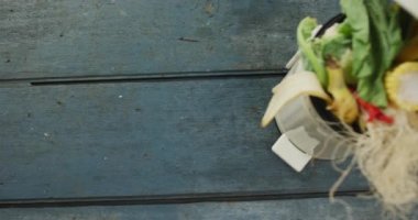 Organik atıklarla dolu beyaz gübre kutusu videosu ve gri ahşap arka planda kopyalama alanı. Füzyon yiyeceği ve taze yemek konsepti.