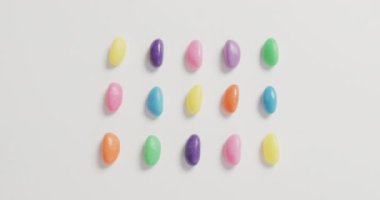 Beyaz arkaplan üzerindeki çok renkli tatlı sıralarının genel görünüm videosu. Füzyon yiyecek ve tatlı konsepti.