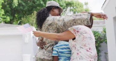 Afro-Amerikan ailesinin eve dönen asker anneyi karşılama videosu. Aile, birliktelik, ordu ve Amerikan vatanseverliği kavramı.