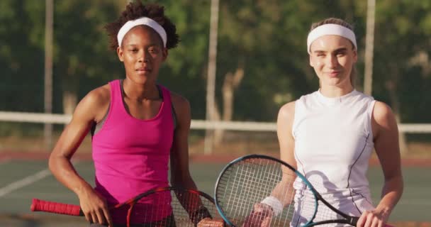 ラケットを持ってカメラを見て幸せな多様な女性テニス選手のビデオ プロテニストレーニングスポーツ競技のコンセプト — ストック動画