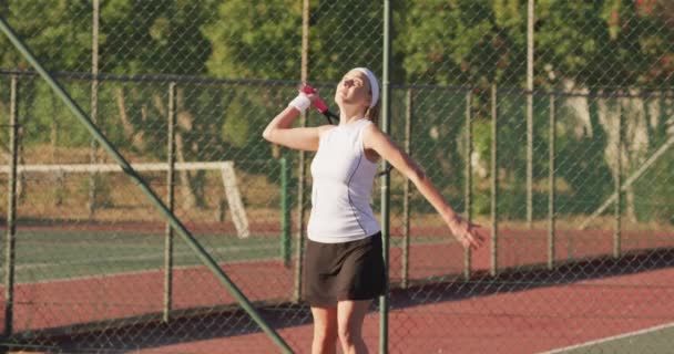 ラケットを持ってボールを打つ幸せな白人女性テニス選手のビデオ プロテニストレーニングスポーツ競技のコンセプト — ストック動画