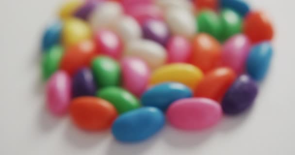 白い背景の上に円を形成する複数の色のお菓子のクローズアップのビデオ 融合食品とお菓子のコンセプト — ストック動画