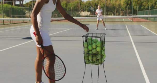 アフリカ系アメリカ人女子テニス選手がラケットを持ち 友人とトレーニングをしている様子 プロテニストレーニングスポーツ競技のコンセプト — ストック動画