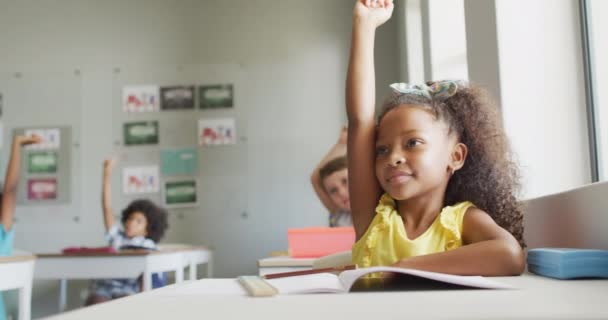 レッスン中に手を挙げている幸せなアフリカ系アメリカ人の少女のビデオ 小学校教育と学習の概念 — ストック動画