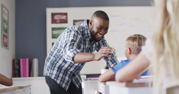 Video Happy African American Teacher Supporting Caucasian Boy Classroom Primary — Stock Video