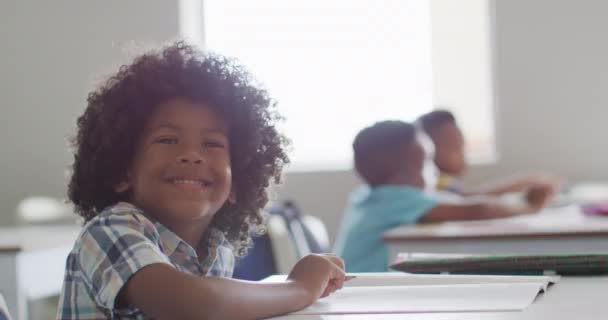 Sınıfta Ders Sırasında Masasında Oturan Mutlu Afrikalı Amerikalı Çocuğun Videosu — Stok video