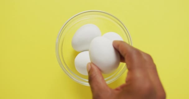 Filmik Nad Głową Widok Szklanej Miski Jajkami Żółtym Tle Żywność — Wideo stockowe