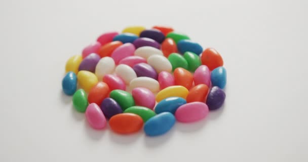 白い背景の上に円を形成する複数の色のお菓子のクローズアップのビデオ 融合食品とお菓子のコンセプト — ストック動画