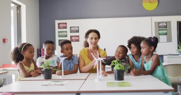 教室で生態学を学ぶ多様な生徒の幸せな白人女性教師とクラスのビデオ 小学校教育と教育の専門職 — ストック動画