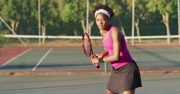 Video Una Jugadora Tenis Afroamericana Enfocada Sosteniendo Raqueta Golpeando Pelota — Vídeos de Stock