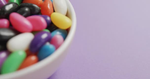 Vídeo Close Doces Multicoloridos Tigela Sobre Fundo Roxo Conceito Alimentos — Vídeo de Stock