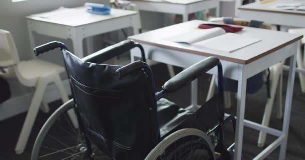 教室の机の上に車椅子が立っている映像 小学校教育 — ストック動画