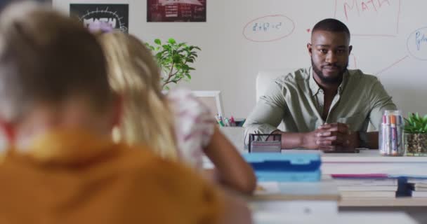 Video Lycklig Afrikansk Amerikansk Manlig Lärare Sitter Vid Skrivbordet Mattelektionen — Stockvideo