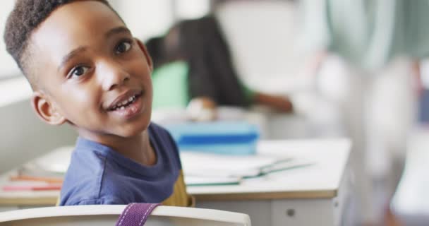Video Lycklig Afrikansk Amerikansk Pojke Sitter Vid Skrivbordet Lektionen Klassrummet — Stockvideo