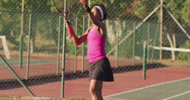 アフリカ系アメリカ人女子テニス選手がラケットを持ってボールを打つ映像 プロテニストレーニングスポーツ競技のコンセプト — ストック動画