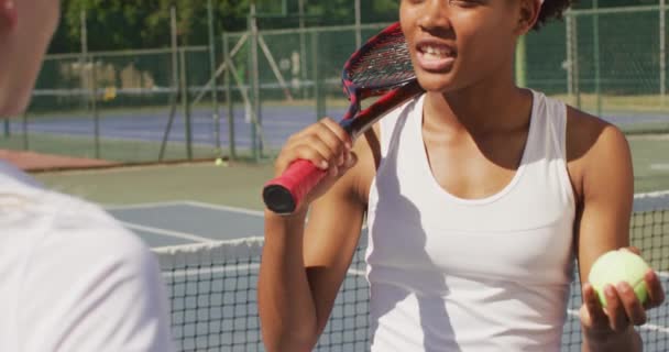 ラケットを持っている幸せなアフリカ系アメリカ人女性テニス選手のビデオや友人と話しています プロテニストレーニングスポーツ競技のコンセプト — ストック動画
