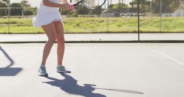 白人女子テニス選手がラケットを持っている様子や友人とのトレーニングの様子を動画でご覧いただけます プロテニストレーニングスポーツ競技のコンセプト — ストック動画