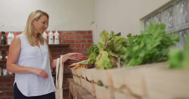 Video Una Mujer Caucásica Recogiendo Zanahorias Orgánicas Frescas Tienda Comestibles — Vídeos de Stock