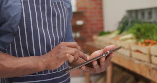 Video Feliz Vendedor Afroamericano Usando Tableta Una Tienda Comestibles Orgánica — Vídeos de Stock